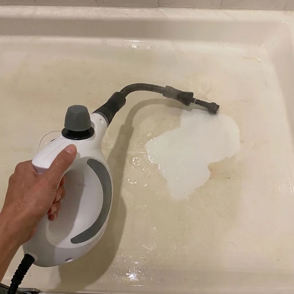 Nettoyage à la vapeur du fond d'une baignoire entartrée