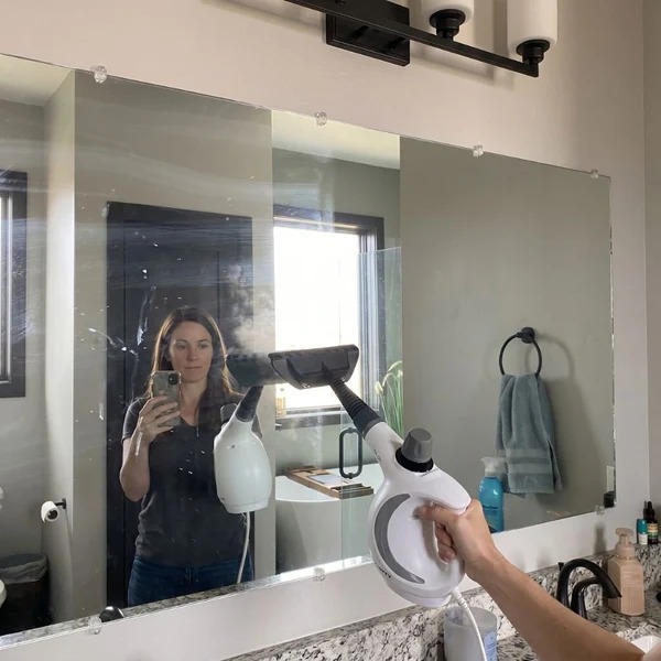 Nettoyage à la vapeur d'un grand miroir de salle de bain